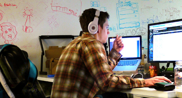 Разработчик игр программирует за компьютером и ноутбуком